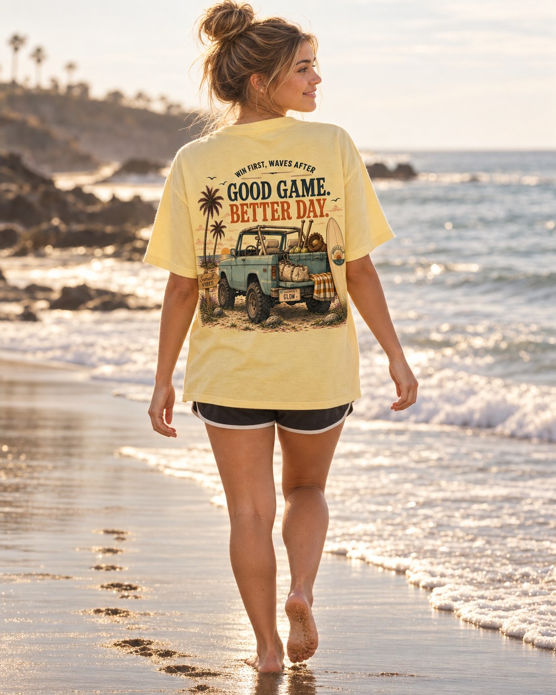 A girl walking the waterline in the Win First, Waves After tee